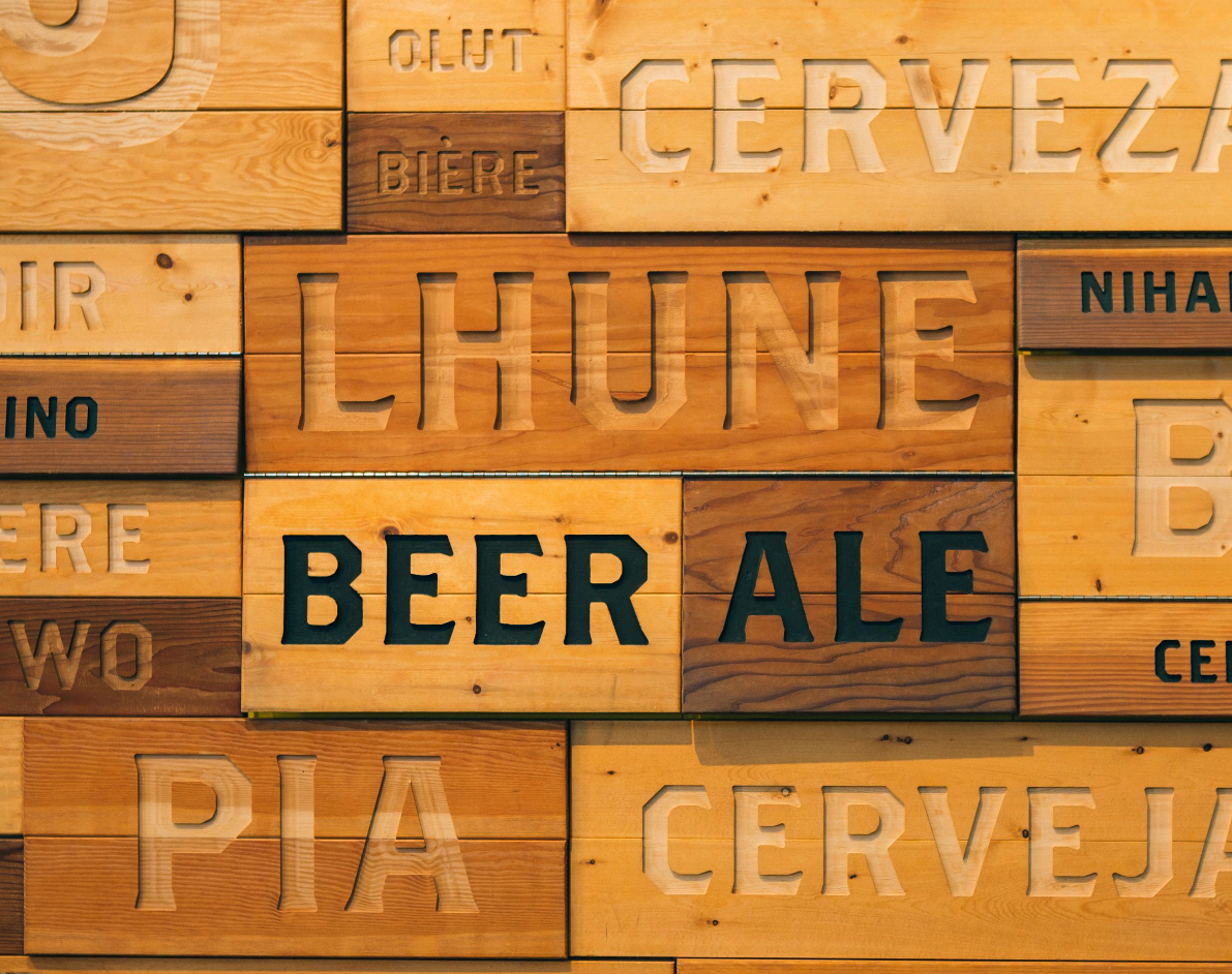 A close up of the wood wall covered in the word "beer" in different languages.