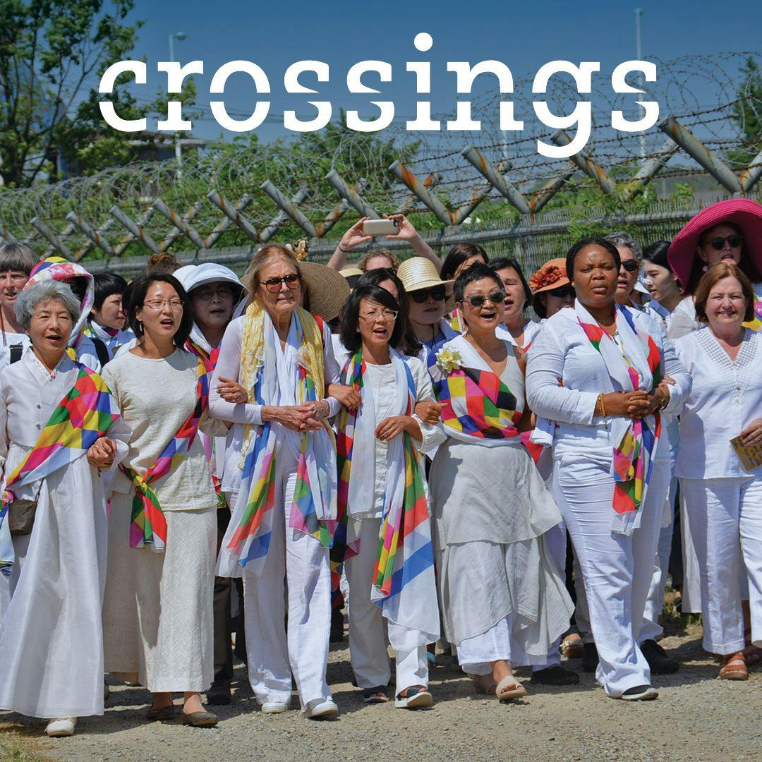 Image from the Crossings documentary featuring a group of several women walking together with their arms interlocked during a peaceful protest march. 