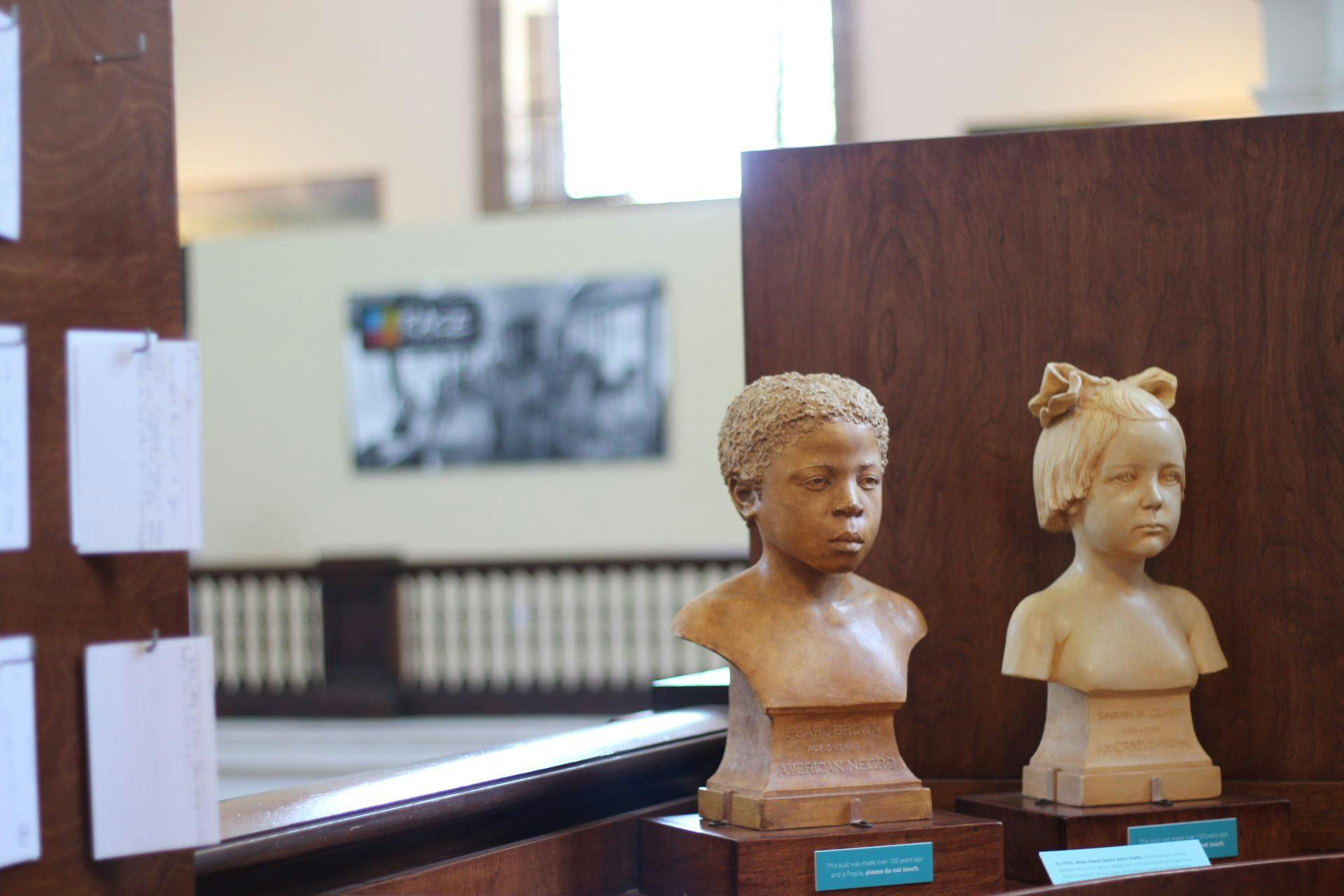 Busts of two children, one Black and one white, sit next to each other in the "Race: Are We So Different?" exhibit.